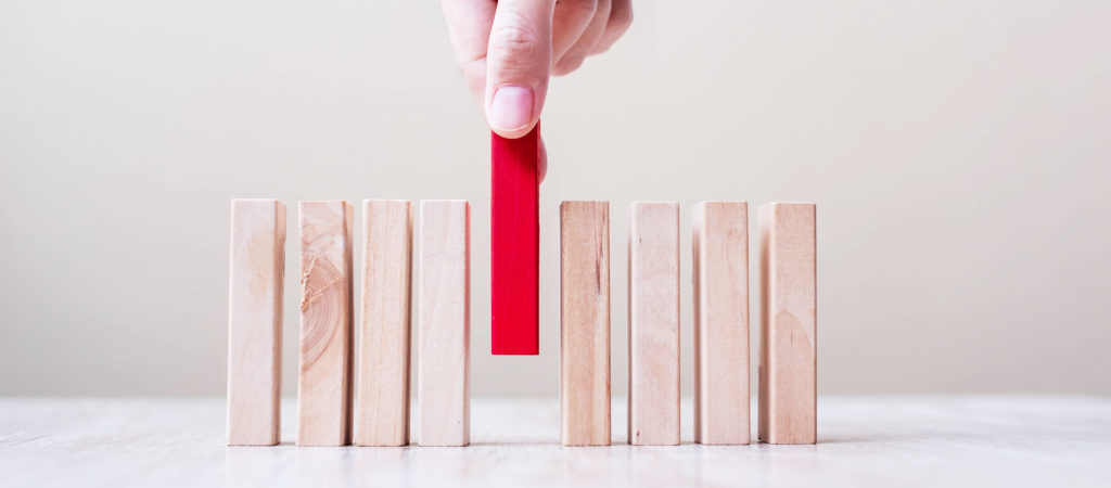 Businessman hand placing or pulling Red wooden block on table. Business planning, Risk Management, Solution, leader, strategy, different and Unique Concepts