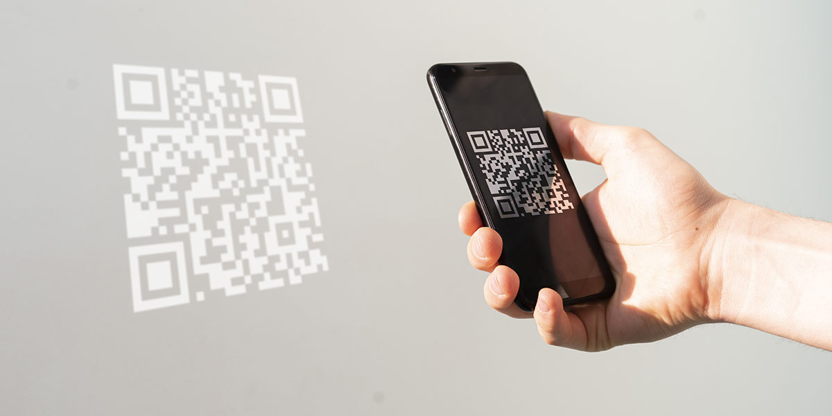 hand holding a smartphone and scan the qr code to make a payment